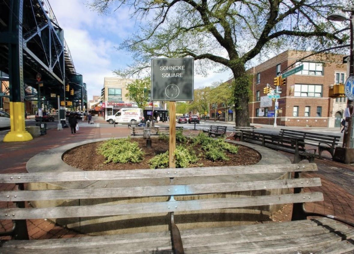Sohncke Square in Woodside with benches beneath the elevated train